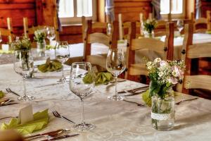 a table with wine glasses and flowers on it at Pension Roubenka in Harrachov