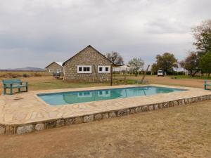 a swimming pool in front of a house at Meteorite Rest Camp in Groutfontein