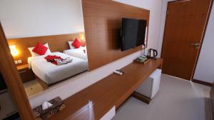 a hotel room with a bed and a mirror at Tom Guest House in Legian