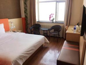 une chambre d'hôtel avec un lit, une table et des chaises dans l'établissement 7Days Inn Beijing Yizhuang Development Zone, à Pékin