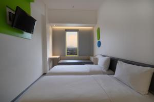 a room with two beds and a window at POP! Hotel Festival Citylink in Bandung