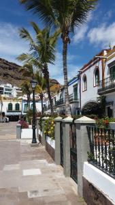 une rue avec des palmiers et un bâtiment dans l'établissement Castillete 5 by El Sirocco, à Puerto de Mogán