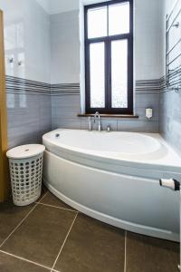 a white bath tub in a bathroom with a window at Riga Lux Apartments - Ernesta, Free parking in Rīga