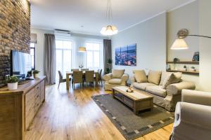 ein Wohnzimmer mit einem Sofa und einem Tisch in der Unterkunft Riga Lux Apartments - Ernesta, Free parking in Riga