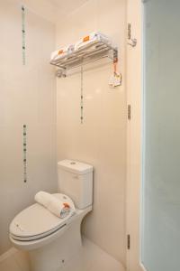 a white bathroom with a toilet and a shower at HARRIS Hotel & Convention Festival Citylink Bandung in Bandung