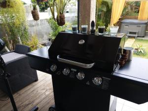 - un poêle noir sur la terrasse avec une table dans l'établissement La Plaine-itude & Spa, à Saint-Paul