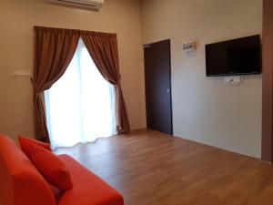 a living room with a couch and a large window at DURIAN HILL VILLA in Gua Musang