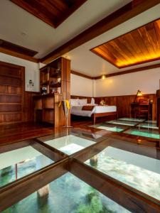 Zimmer mit einem Bett und einem Glasboden in der Unterkunft Sunlight Ecotourism Island Resort in Culion Reservation