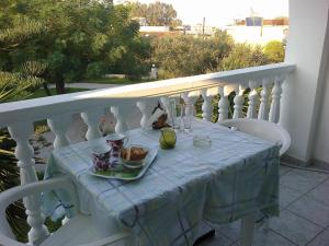 un tavolo con un piatto di cibo su un balcone di Smile's Studios a Tsilivi