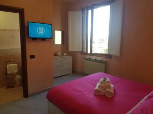 a bedroom with a bed with two pairs of slippers at Piccolo Poggio Apartments in Florence