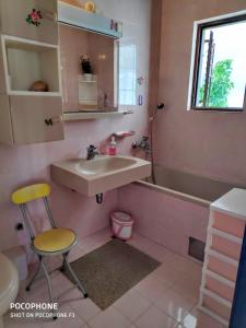 a pink bathroom with a sink and a chair at Apartments Tamaris in Zaostrog
