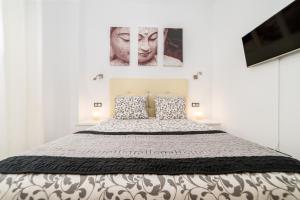 una camera da letto con un letto e due quadri sul muro di NEW! Málaga Suite with pool and parking in the center! a Málaga Altre 20 foto
