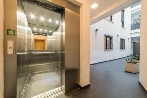 een hal met een metalen lift in een gebouw bij Málaga Suite Picasso in Málaga