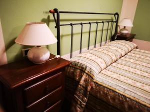 a bedroom with a bed with a lamp on a dresser at Locanda Miranda in Tellaro