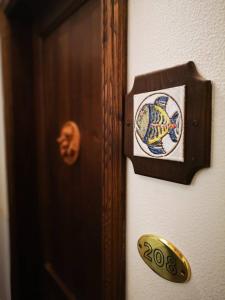 a sign on a door with a fish on it at Locanda Miranda in Tellaro