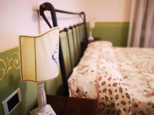 a lamp sitting on a table next to a bed at Locanda Miranda in Tellaro