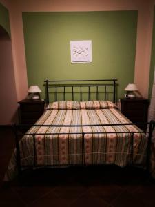 a bedroom with a bed with a plaid blanket and two lamps at Locanda Miranda in Tellaro