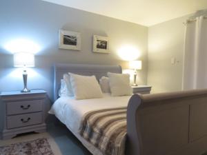 a bedroom with a bed with two night stands and two lamps at Oppidraai B in Paternoster