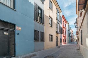 un vicolo con edifici colorati in una città di NEW! Málaga Suite with pool and parking in the center! a Málaga