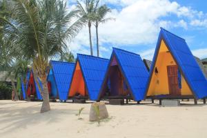 a row of colorful houses on a beach with palm trees at New Hut Bungalow in Lamai