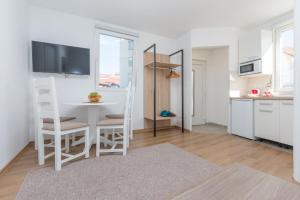a kitchen and dining room with a white table and chairs at Apartments "Tuffo" in Sarajevo