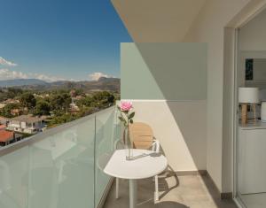un balcón con una mesa blanca y un jarrón con una flor en Hotel Villa Luz, en Gandía