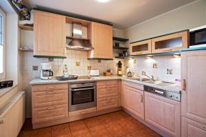 a large kitchen with wooden cabinets and appliances at Ferienwohnung Reddemann in Westerstede