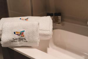 a white towel sitting on top of a bath tub at Sicilia's Art Hotel & Spa in Acitrezza