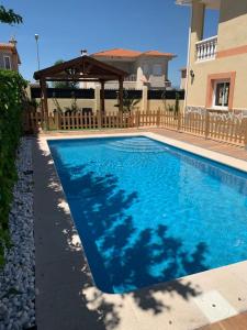 a blue swimming pool in front of a house at La Gitana in Santa Olalla de Toledo