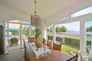 a dining room with a table and views of the ocean at Villa Xata in Port de Pollensa