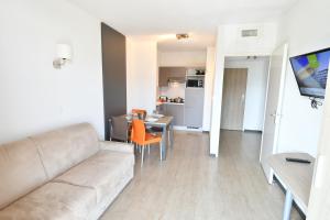 a living room with a couch and a table at Appart-Hôtel Mer & Golf City Bordeaux - Bruges in Bruges