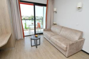 a living room with a couch and a table at Appart-Hôtel Mer & Golf City Bordeaux - Bruges in Bruges