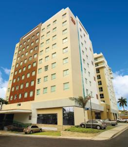 a large building with cars parked in a parking lot at Express Vieiralves in Manaus