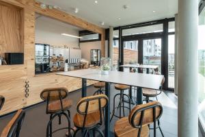 eine Küche mit einem Tisch und einigen Stühlen in der Unterkunft a2 HOTELS Denkendorf - Airport & Messe in Denkendorf