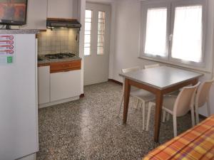 リニャーノ・サッビアドーロにあるBiancaのキッチン(テーブル、椅子、冷蔵庫付)