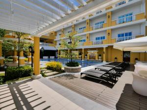 a hotel courtyard with chairs and a swimming pool at Sunlight Guest Hotel, Coron, Palawan in Coron