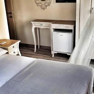 a bedroom with a white desk and a bed at Ege Otel in Cesme
