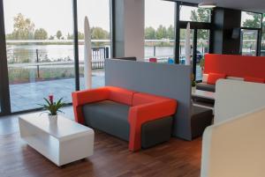 a room with a chair and a table and a surfboard at Appart-Hôtel Mer & Golf City Bordeaux - Bruges in Bruges
