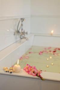 a candle and some pink flowers on a counter at Grand Hotel Urban in Antananarivo