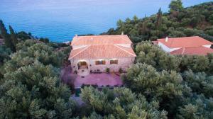 an aerial view of a house on a hill next to the water at Zante Xigia Bay villas in Khartáta