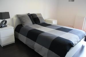 ボルドーにあるappartement bordeaux lacのベッドルーム(黒と白のベッド、ナイトスタンド付)