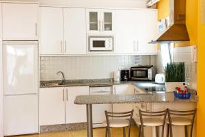 een keuken met witte kasten en een aanrechtblad bij Playa Mogan Golden Beach 1 by El Sirocco in Puerto de Mogán