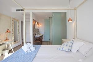Boutique Hotel Petit Sant Miquel في Calonge: غرفة نوم بسرير ابيض عليها مناشف