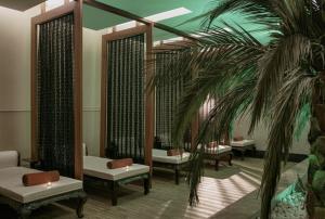 uma sala de espera com cadeiras e uma palmeira em Botanik Platinum Hotel em Okurcalar