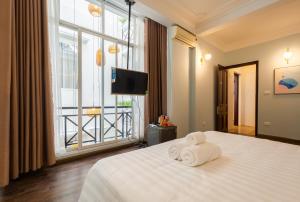 a hotel room with a bed with towels on it at Ohana House in Hanoi +28 photos