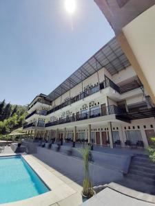 ein großes Gebäude mit einem Pool davor in der Unterkunft Albero Hotel Bogor in Bogor