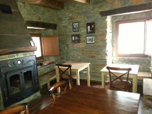 a kitchen with a fireplace and a table and chairs at Hostal De Montaña La Aldeya in Villablino