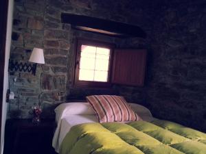 a bedroom with a bed in a stone wall at Hostal De Montaña La Aldeya in Villablino