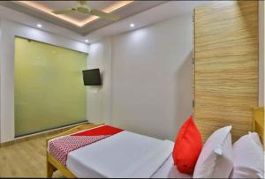 ein Schlafzimmer mit einem Bett und einem Fernseher an der Wand in der Unterkunft HOTEL CENTRE POINT in Mundra