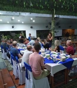 un grupo de personas sentadas en mesas comiendo comida en Khách Sạn Ngọc Hân en Ấp Vĩnh Phú